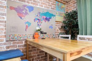 a wooden table in a room with a world map on the wall at nestay inn tokyo senju in Tokyo