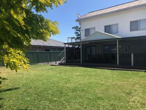 a house with a lawn in front of it at Callala Beach Shack - Pet Friendly in Callala Beach