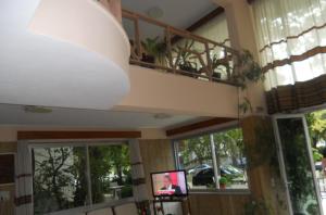a living room with a television and a balcony at Rex Chasioti in Loutra Ipatis