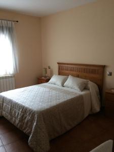 1 dormitorio con 1 cama con sábanas blancas y ventana en Casa Rural El Pilón, en Santibáñez el Alto