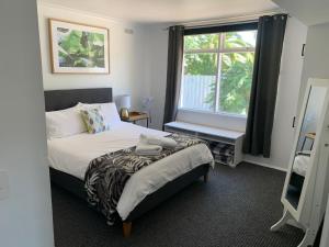a small bedroom with a bed and a window at Kings Avenue Motel in Saint Arnaud