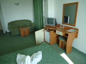 a room with a desk with a television and a couch at Guesthouse Ruskovi in Ravda +44 photos