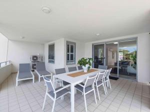 a dining room table and chairs in a room at Pacific Marina Apartments in Coffs Harbour