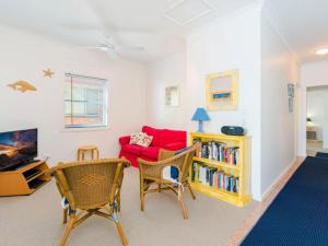 a living room with a red couch and chairs at Avalon 4 in Yamba