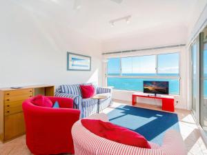 a living room with red furniture and a large window at Avalon 4 in Yamba