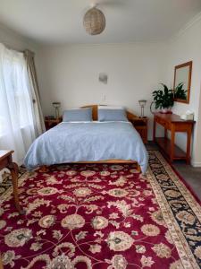a bedroom with a bed and a red rug at HomeWell in Tauranga
