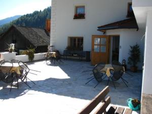 a patio with chairs and a table and a building at Messnerwirt Onach in San Lorenzo di Sebato +18 photos