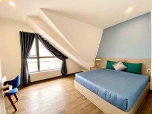 a bedroom with a blue bed and a window at Kim Oanh Apartment in Da Lat