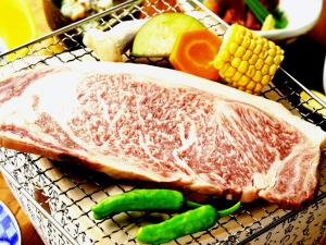 a rack with a piece of meat and vegetables on it at Minshuku Asogen in Aso