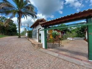 a brick road next to a house with a palm tree at Flat em Lençóis apartamento 003 in Lençóis