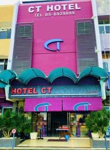 a pink hotel with a hotel sign on it at Ct Hotel in Sitiawan