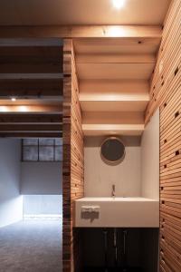 a bathroom with a sink and wooden walls at cup of tea ensemble in Takayama