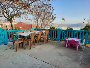une table, des chaises et une clôture bleue dans l'établissement Mandala in Mount מנדלה בחרמון סוויטה, à Majdal Shams