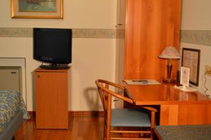 a room with a desk with a tv on a desk sidx sidx sidx at Hotel Sagittario in Padova