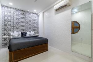a bedroom with a bed and a glass wall at OSI Apartments Jogeshwari West in Mumbai +15 photos