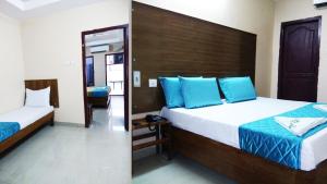 拉賈蒙德里的住宿－Sona Residency，一间卧室配有两张带蓝色枕头的床