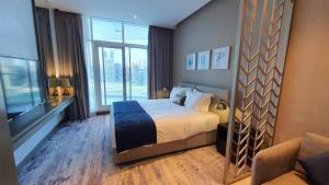 a hotel room with a bed and a large window at Blue Ocean Holiday Homes - Prive in Dubai
