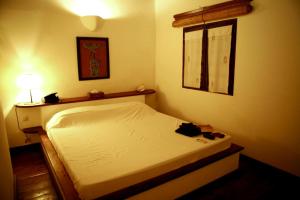 a small bedroom with a bed and a window at Hotel O Sole Mio in Assinie