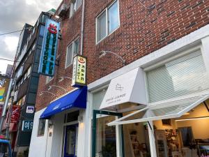 a store front of a brick building with a sign at Dante House in Busan