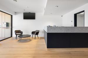 a kitchen with a counter and chairs and a table at Springs Newcastle in Newcastle