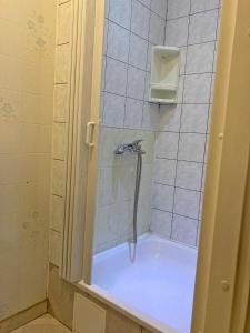 um chuveiro com uma mangueira numa casa de banho em azulejo em Motelis Astarte em Koknese