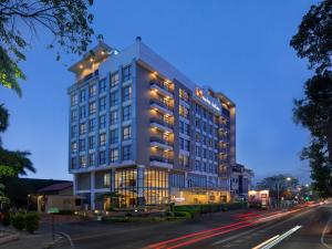Swiss-Belinn Gajah Mada Medan في ميدان: مبنى ابيض كبير على شارع المدينة بالليل