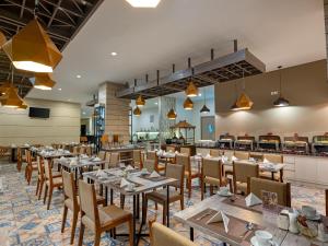 une salle à manger avec des tables et des chaises ainsi qu'un bar dans l'établissement Swiss-Belinn Gajah Mada Medan, à Medan