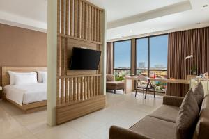 um quarto com uma cama e uma televisão num quarto em Swiss-Belinn Gajah Mada Medan em Medan