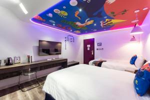 Cette chambre comprend 2 lits et un plafond orné d'une fresque murale représentant des poissons. dans l'établissement Norway Forest Travel hotel 1 Taichung, à Taichung