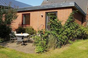 a patio with a table and chairs in front of a brick house at Urlaub zwischen den Meeren auf Hof Jørlon in Osterby