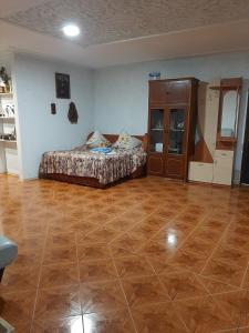 a bedroom with a bed and a wooden floor at Семейный отдых у моря в Черноморке in Odesa