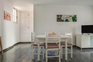 a dining room with a white table and chairs at Casa Caletillas in Candelaria