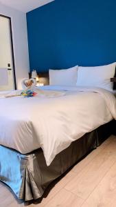 a large white bed in a room with a blue wall at Greenight Hotel in Taichung