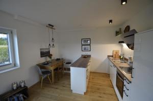 een keuken met witte muren en een houten tafel bij Bergnest Bad Bayersoien in Bayersoien