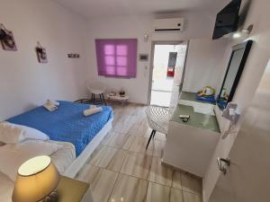 een slaapkamer met een bed en een tafel en een paars raam bij Villa Anto in Fira