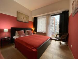 een rode slaapkamer met een bed en een raam bij Brial apartment 2 bedrooms, in Antwerpen
