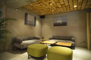 恒春鎮にあるFFF Hotelのソファ2台、テーブル、椅子が備わる客室です。