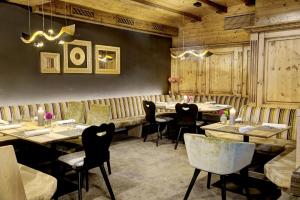 a restaurant with wooden walls and tables and chairs at Brandlhof lodge in Saalfelden am Steinernen Meer