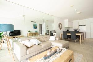 Cairns Waterfront Luxury at Harbourlights في كيرنز: غرفة معيشة مع أريكة وطاولة