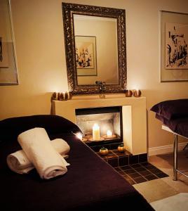 a room with a fireplace with a mirror and candles at Vair's Place Guest House in Sandton Paulshof - Apartment, Lux Suites & Spa in Johannesburg