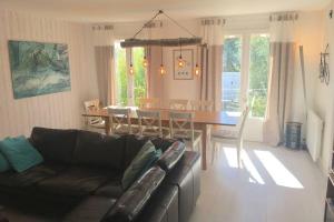 a living room with a couch and a dining room table at MAISON 120m2 près centre et plages classée *** in Le Bois-Plage-en-Ré