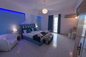 a bedroom with a bed and a couch and a chair at Saraya Resort in Alinda