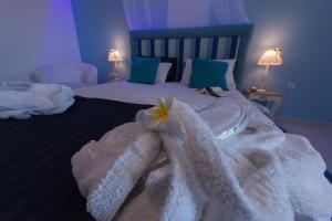 a bedroom with a bed with white towels and a flower on it at Saraya Resort in Alinda