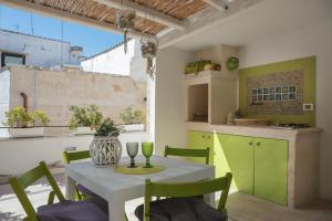 a kitchen with a table and chairs and a kitchen with green cabinets at HolidayMonopoli in Monopoli