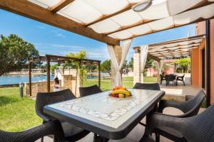 a table with a bowl of bananas on it on a patio at Apartments Amfora Plava Laguna in Umag