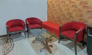 Habitación con 3 sillas y mesa de cristal. en Itsy By Treebo - Auzone & Spa, en Chandīgarh