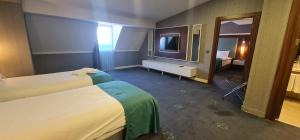 una camera d'albergo con due letti e una televisione di Premier Inn Sakarya a Sakarya