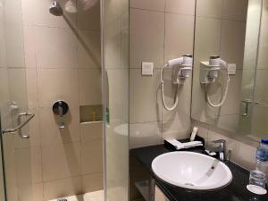 La salle de bains est pourvue d'un lavabo et d'une douche. dans l'établissement PRIME PARK Hotel Bandung, à Bandung