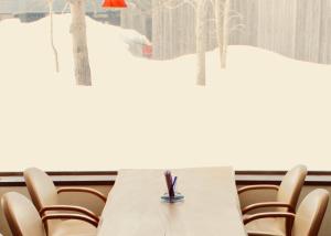 a table and chairs in a room with snow at Appi Arts Color in Hachimantai