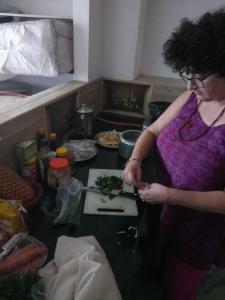 a woman standing in a kitchen preparing food at La Casa Art Stay in Udaipur